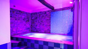 A modern bathroom with a stone wall, a tiled shower area, and a checkered floor. - L' Aia Resort (Trentinara)