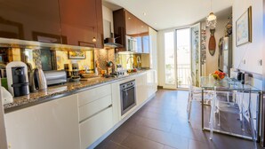 Una cocina moderna con armarios blancos, encimera de granito y electrodomésticos de acero inoxidable.