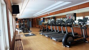 Uma academia com esteiras, bicicletas ergométricas e aparelhos de musculação.