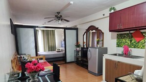 A compact kitchen with a refrigerator, a sink, and a dining area with a table and chairs. - 1 Bedroom Condo at One Oasis Condominuim (Cagayan de Oro)