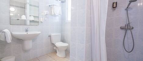 A modern bathroom with a sink, toilet, and shower.