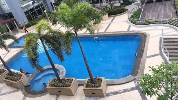 Una piscina rodeada de palmeras y un edificio moderno.
