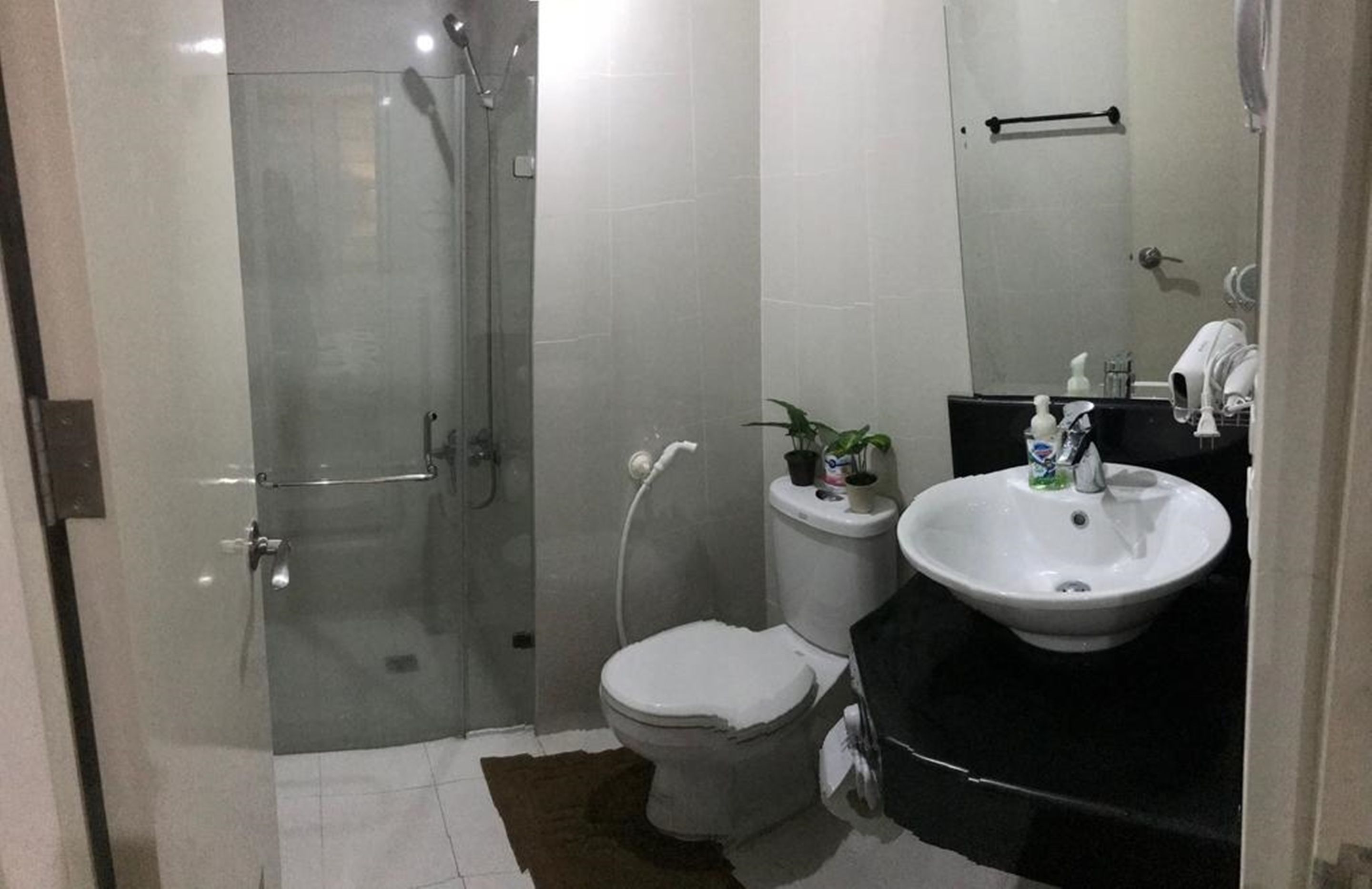 Une salle de bain avec une douche à parois de verre, des toilettes et un lavabo avec un miroir.