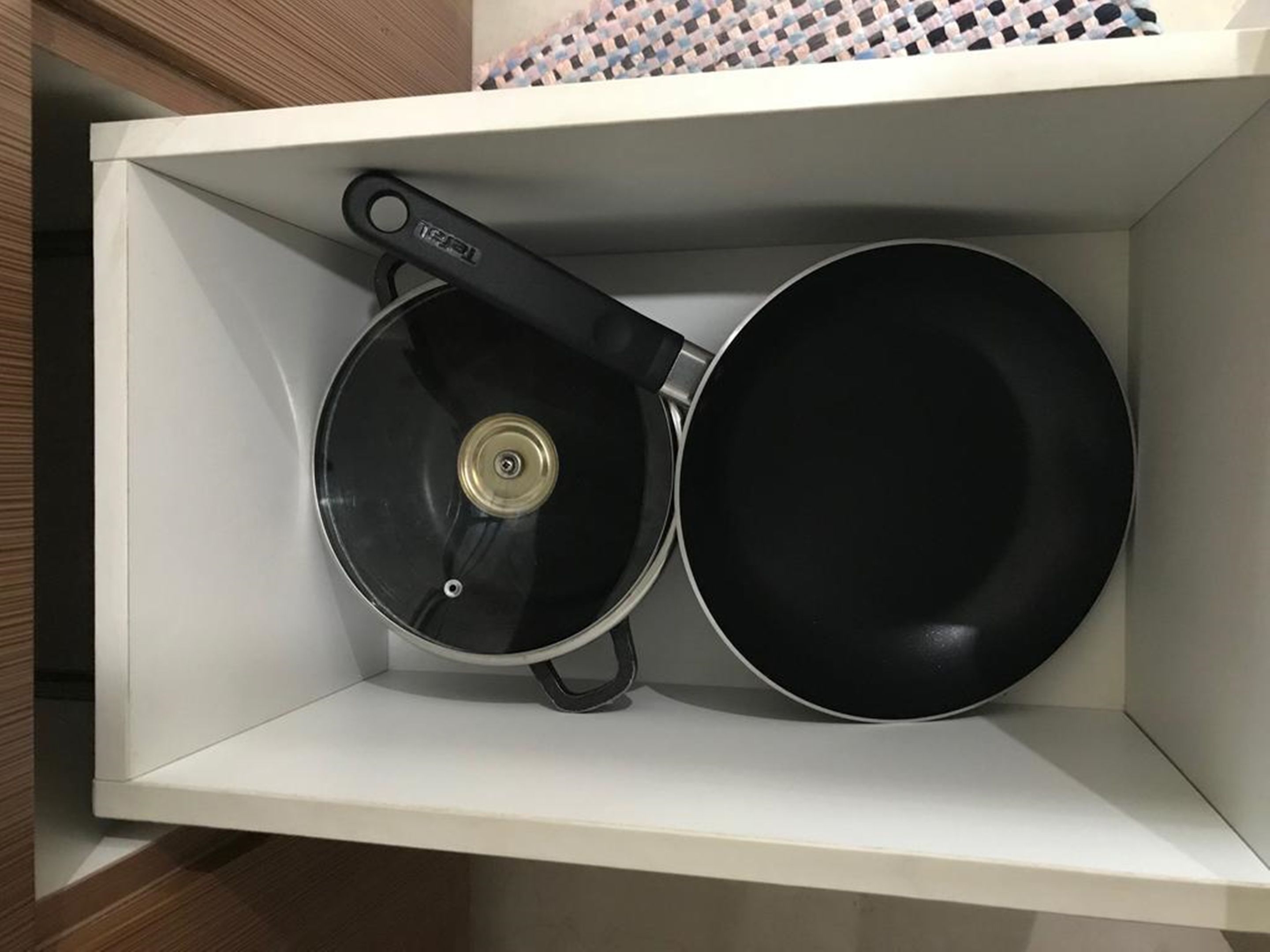 A kitchen drawer containing a frying pan and a pot.