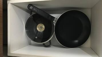 A kitchen drawer containing a frying pan and a pot.