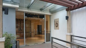 Entrada de un edificio con un cartel que dice "Cluster D".