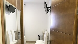 A modern bathroom with a mirror, a sink, and a toilet. - Hostal Restaurante El Mero (Barbate)