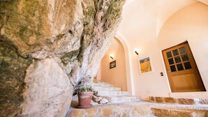 A stone staircase leading to a wooden door with a glass panel, flanked by arched walls and a potted plant. - QUAI DES MARINIERES AP2015 by RIVIERA HOLIDAY HOME (Villefranche-sur-Mer)