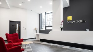 A reception area with a black wall, a window, and a reception desk. - Destiny Student - New Mill (Dublin)