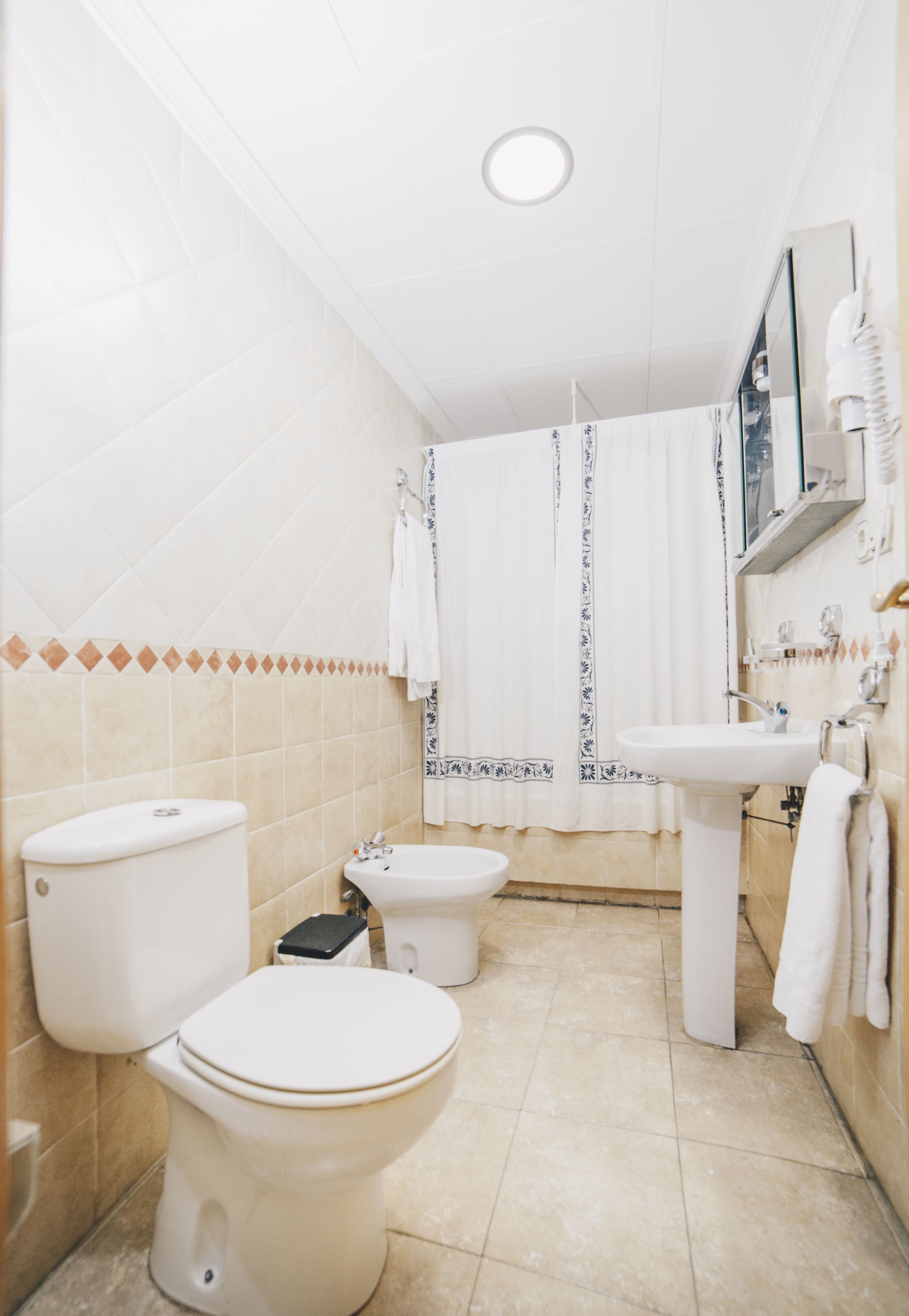 A bathroom with a toilet, bidet, and sink.