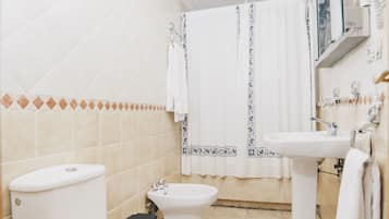 A bathroom with a toilet, bidet, and sink.