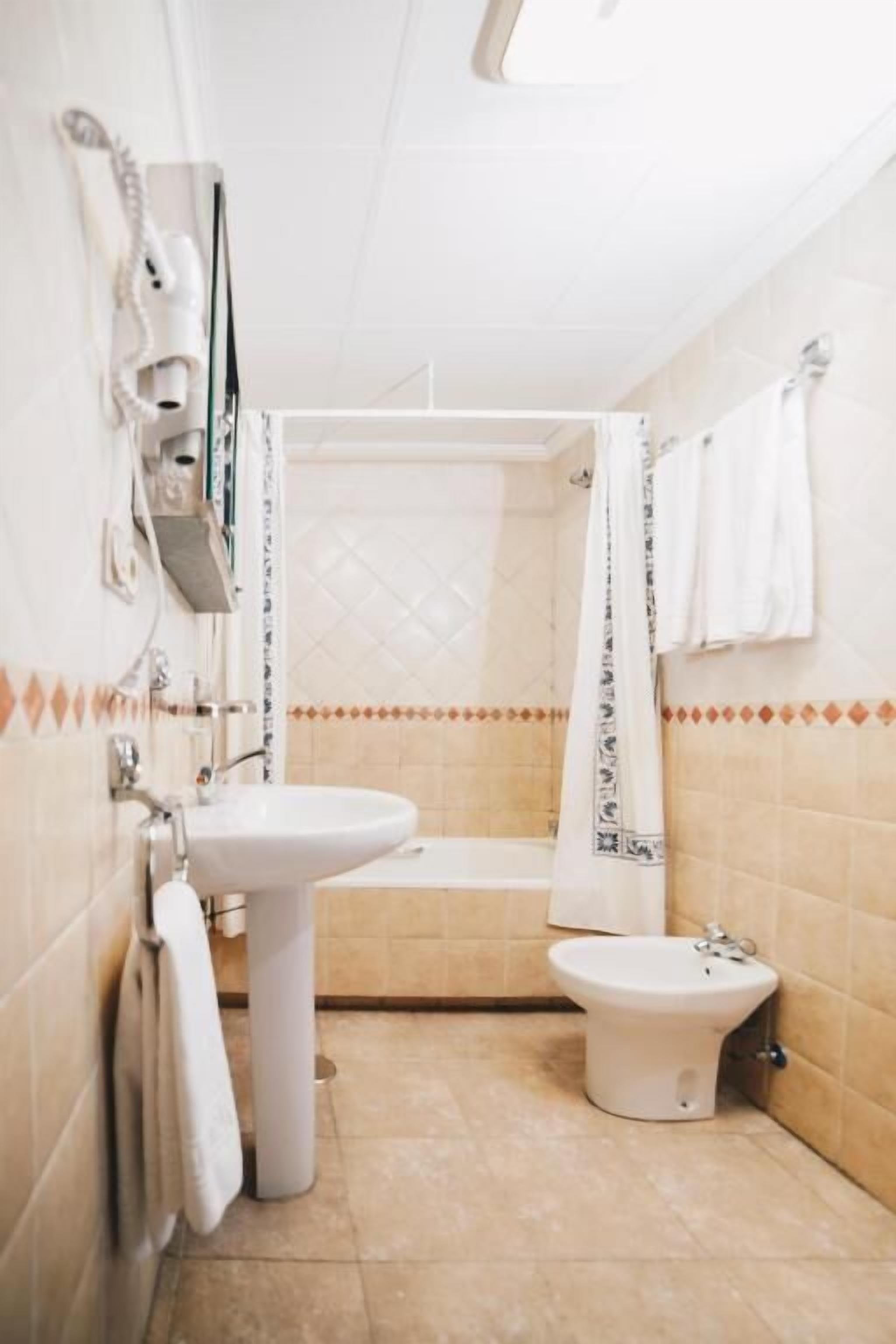 A bathroom with a sink, toilet, and bathtub.
