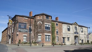 A historic building with a sign for 'Wynnstay Arms' indicating it is a pub. - Wynnstay Arms (Wrexham)