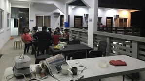 A dining area with tables and chairs, a staircase, and a railing. - Seabreeze Beach Lodge (Nasugbu)