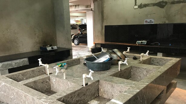 A public restroom with marble sinks and faucets, a trash bin, and a 'No Smoking' sign. - Seabreeze Beach Lodge (Nasugbu)