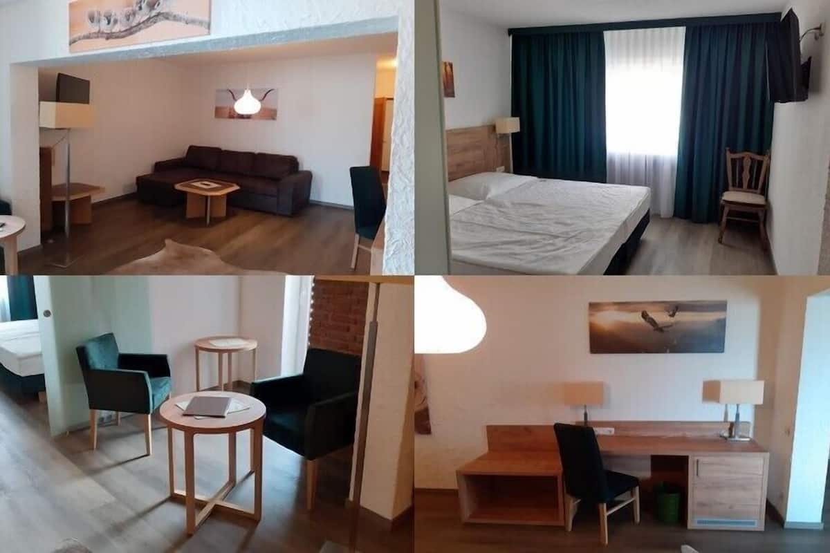 Ein Hotelzimmer mit einem Bett, einem Schreibtisch, einem Sessel, einer Couch und einem kleinen Tisch.