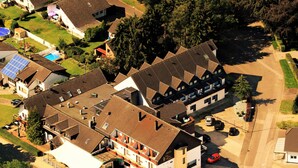 Eine Vogelperspektive auf ein Wohngebiet mit mehreren Häusern, einem Hotel und einer Straße.