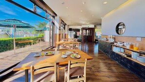 A restaurant with wooden tables and chairs, a bar area with a mirror, and a view of a body of water through large windows. - Nojiri Lake Resort (Shinano)