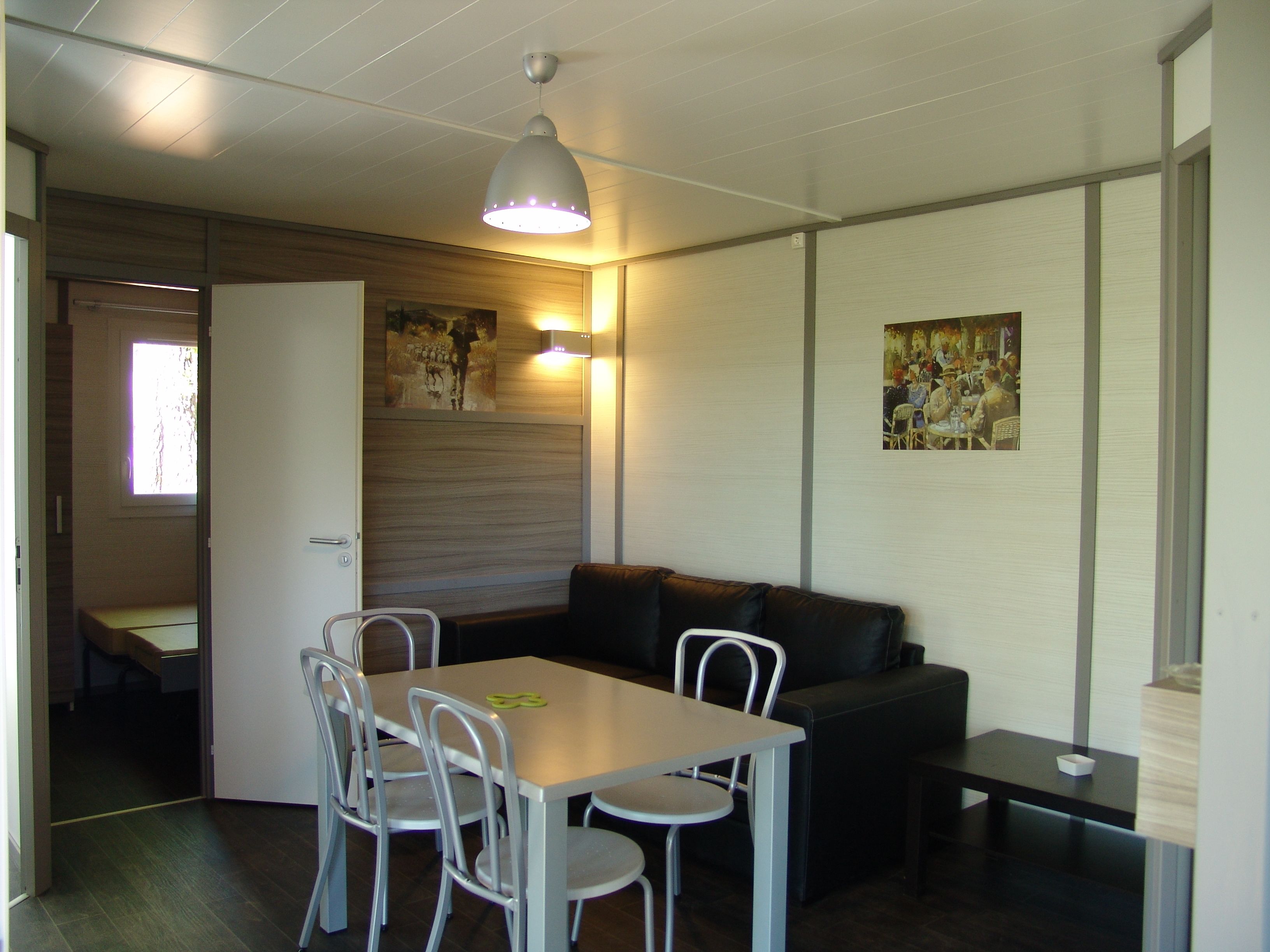 Un espace de vie compact comprenant un coin repas, un canapé et une petite table.