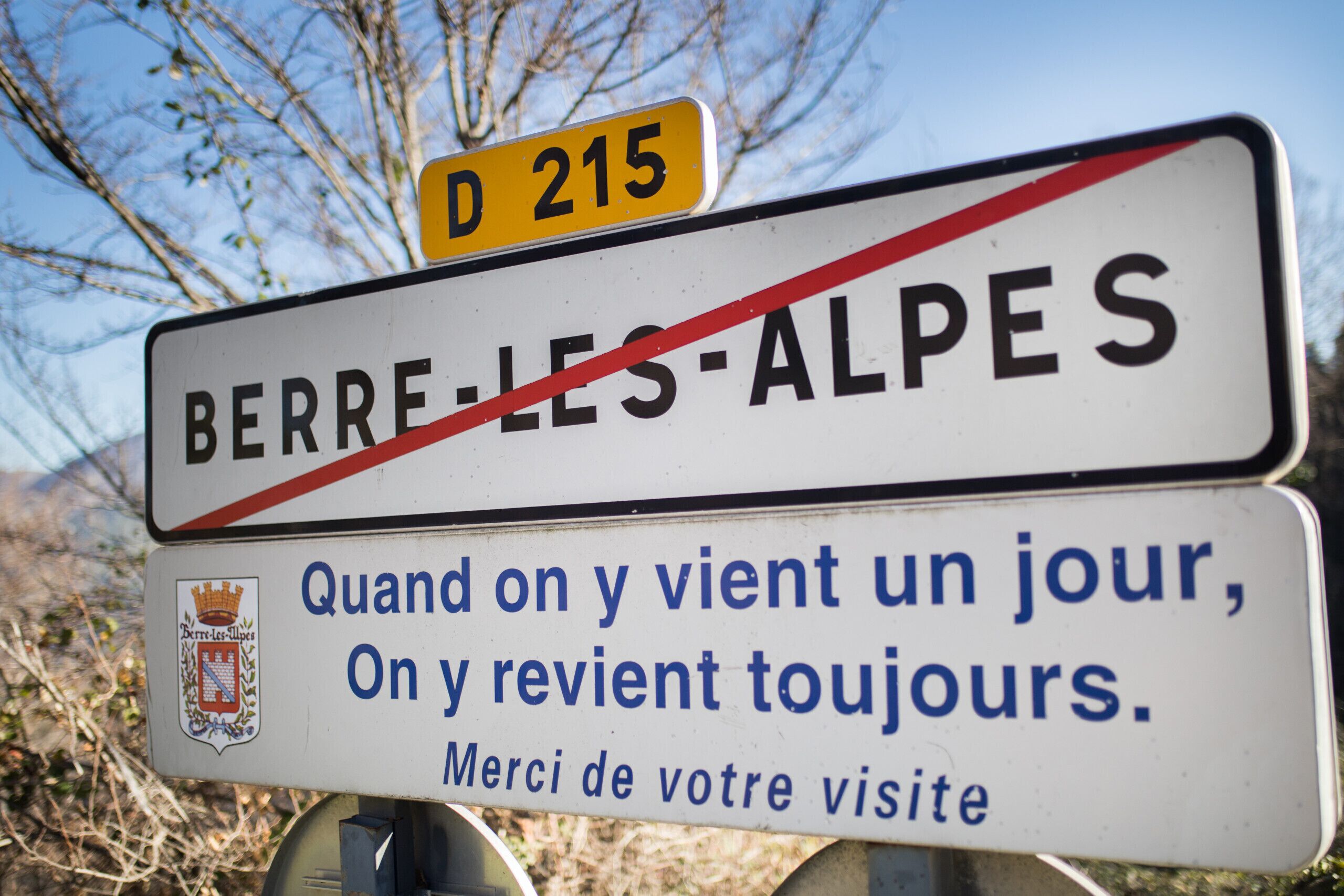 A bilingual sign with 'BERRE-LES-ALPES' and a message in French.