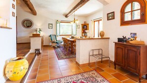 A spacious kitchen with a dining area, wooden beams, a large window, and a rustic decor. - VILLA ROCHE GRISE VI3010 by RIVIERA HOLIDAY HOMES (Berre-les-Alpes)