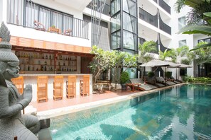 A modern hotel with a swimming pool, outdoor seating, and a statue. - Sumeru Angkor Residence (Siem Reap)