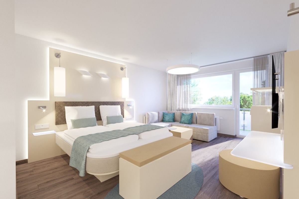 Una habitación de hotel moderna con una cama grande, un sofá, un escritorio y un baño.
