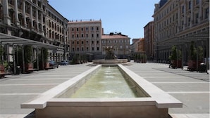 A wide, open plaza with a central water feature and a statue. - Affittacamere Berzi (Trieste)