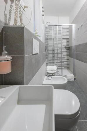 A modern bathroom with a bathtub, toilet, and sink. - Affittacamere Berzi (Trieste)