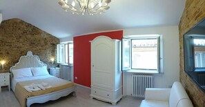 A bedroom with a bed, a wardrobe, a radiator, and a window. - B&B La Lanterna (Fermo)
