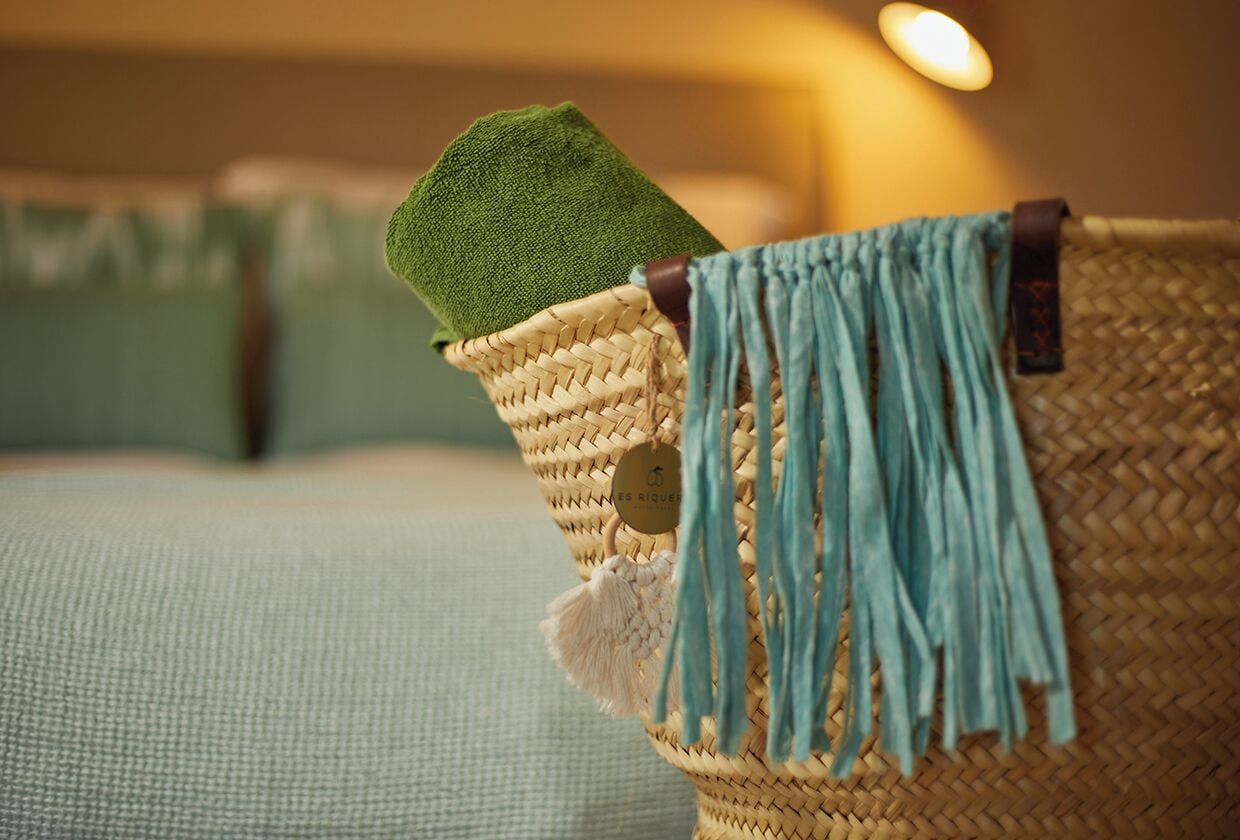 Uma cadeira de vime com almofada verde e umador azul.