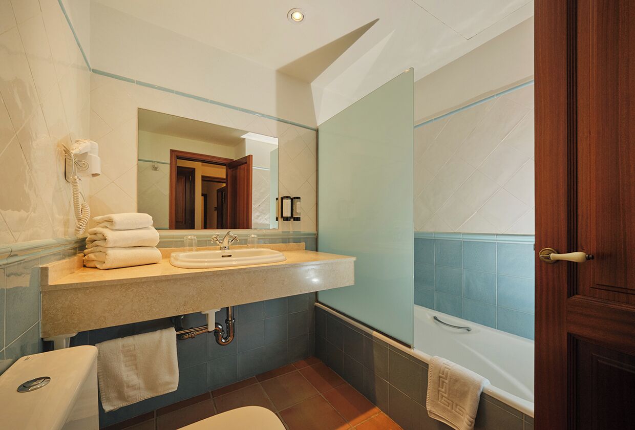 Un baño con lavabo, espejo y bañera.