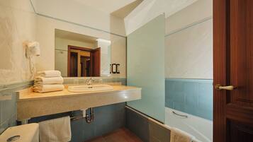 Un baño con lavabo, espejo y bañera.