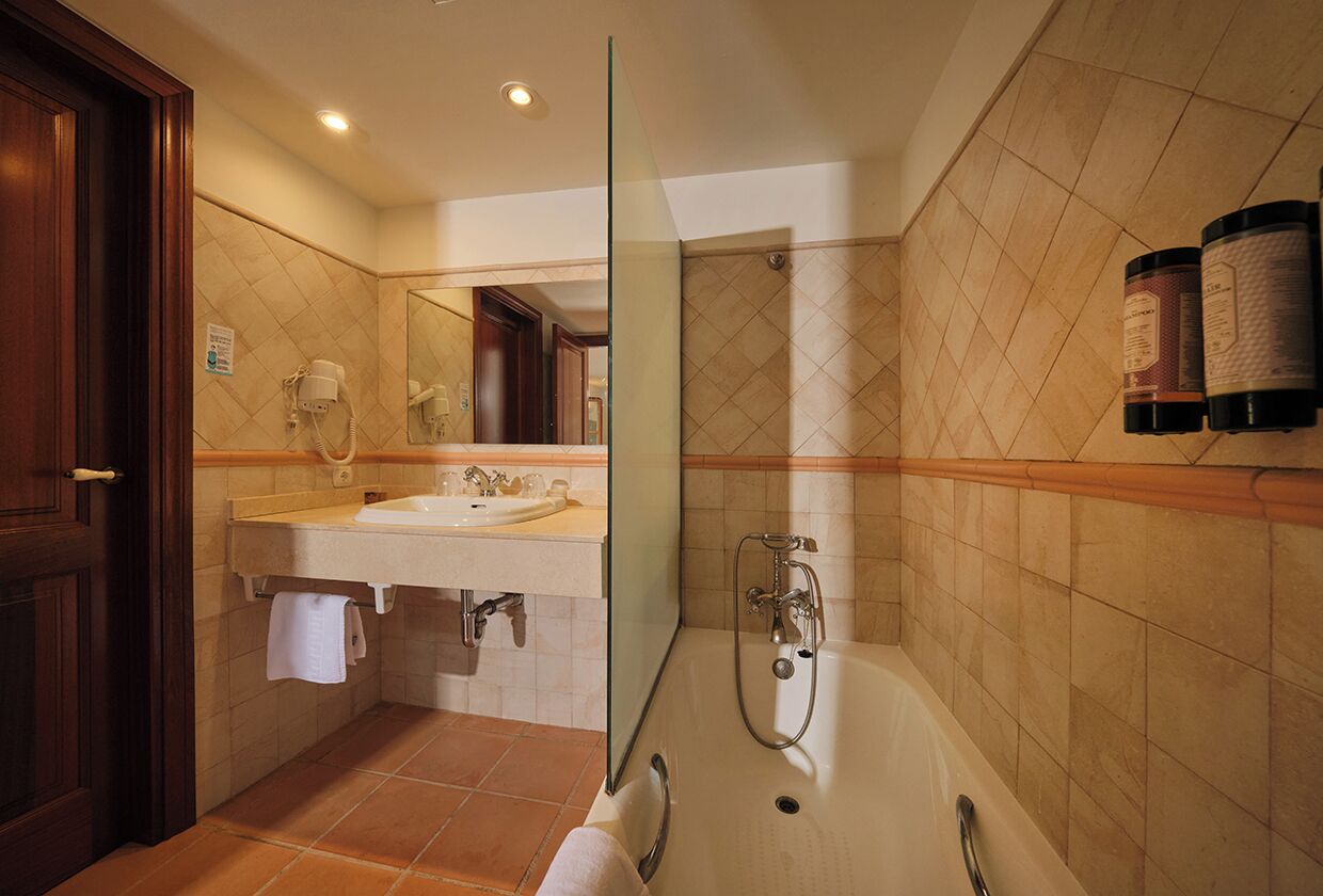 Un baño con cabina de ducha de vidrio, lavamanos doble y espejo.
