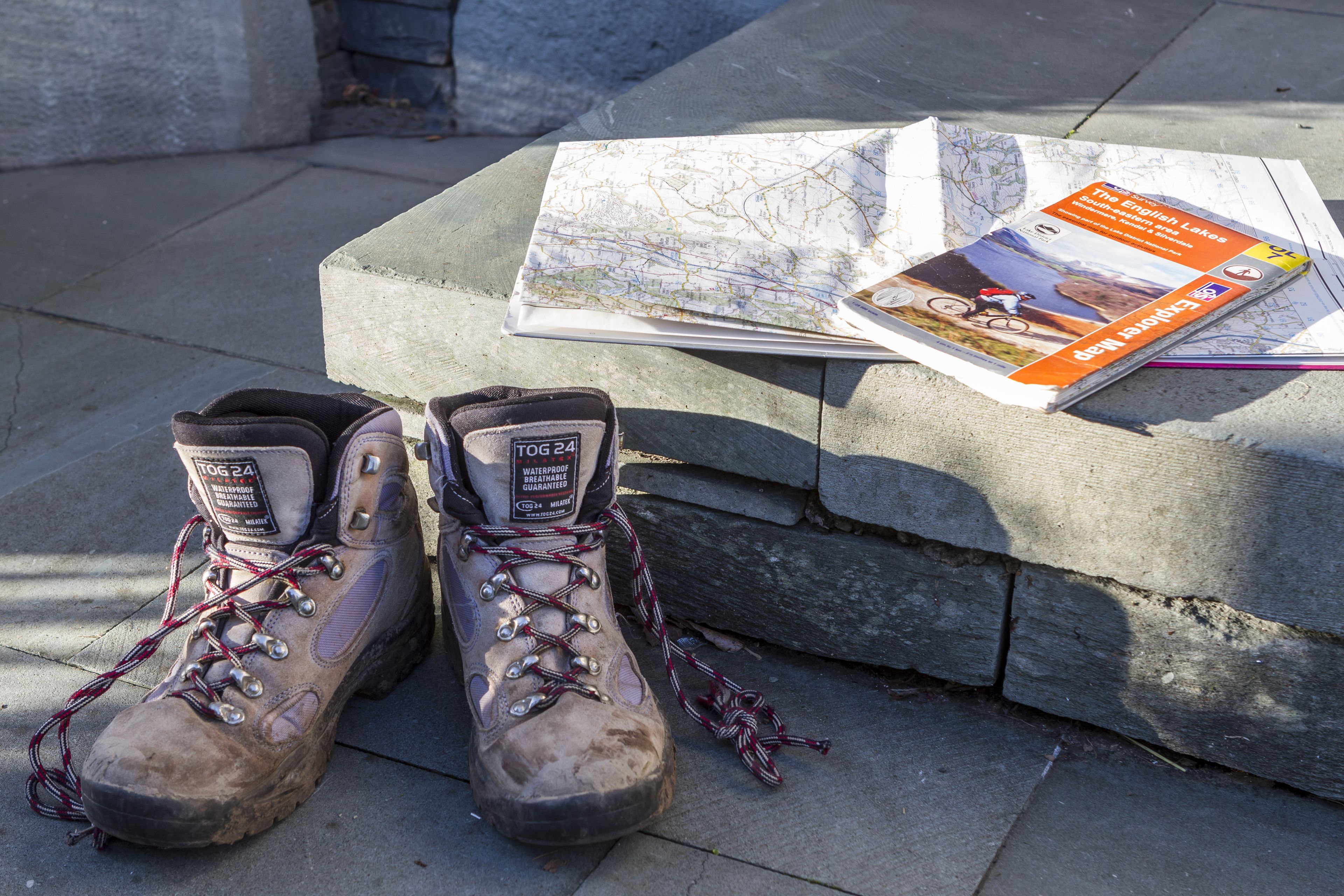 Wandelboots en een kaart op een stenen bank.