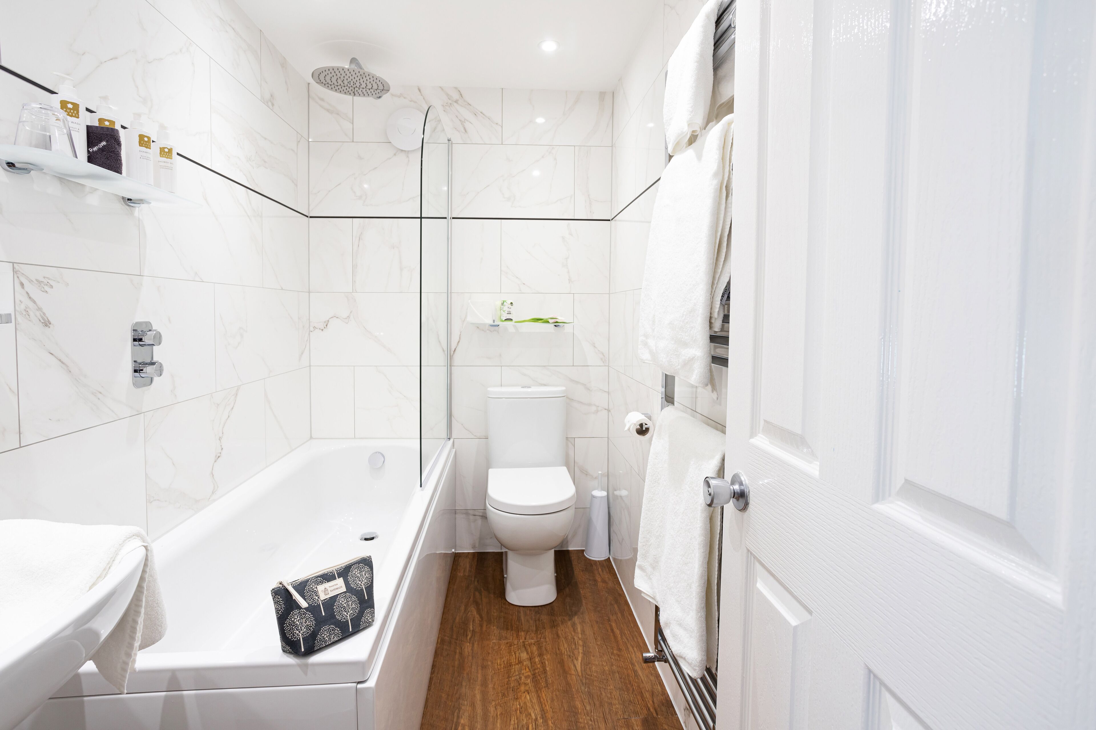 A modern bathroom with a bathtub, toilet, and shower.