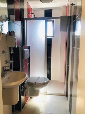 A compact bathroom with a toilet, sink, and shower. - Boss II Hotel (Eceabat)
