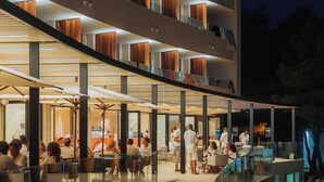 A modern outdoor dining area with multiple levels and glass railings, surrounded by natural scenery. - Hotel Serawa Moraira (Teulada)