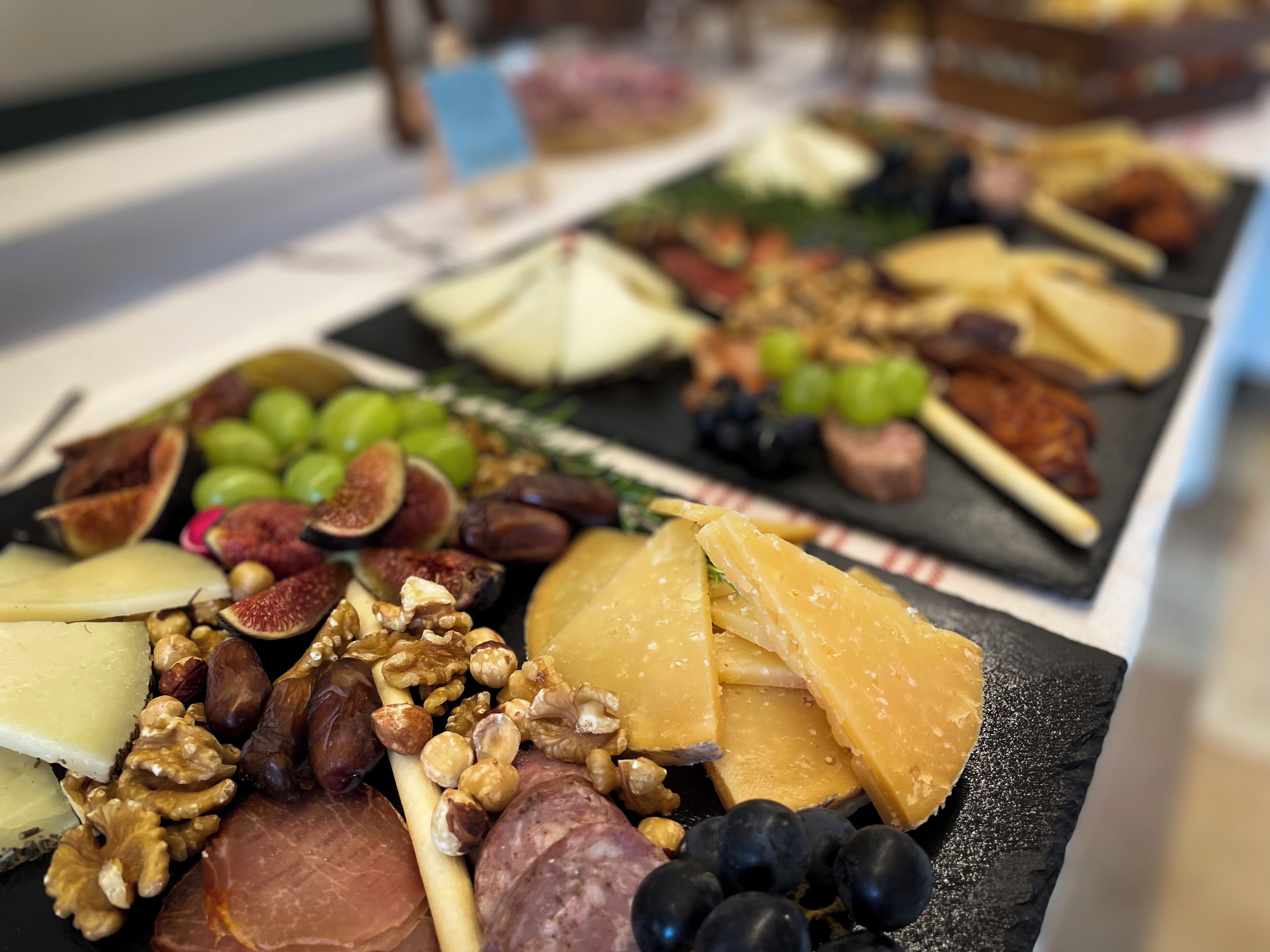 A charcuterie board with various cheeses, fruits, and nuts.