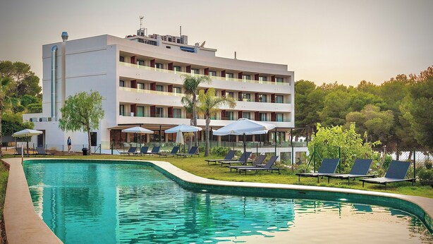 A hotel with a swimming pool, multiple balconies, and outdoor seating areas. - Hotel Serawa Moraira (Teulada)