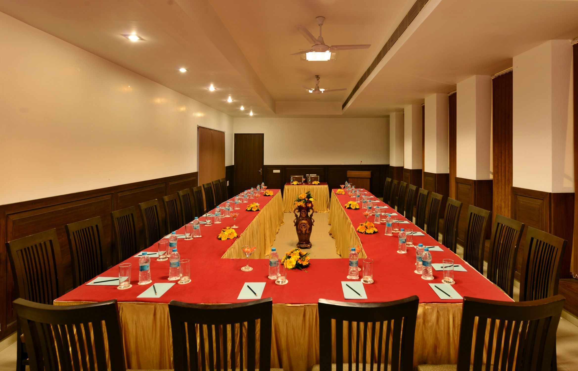 A conference room with a long table, chairs, and a ceiling fan.