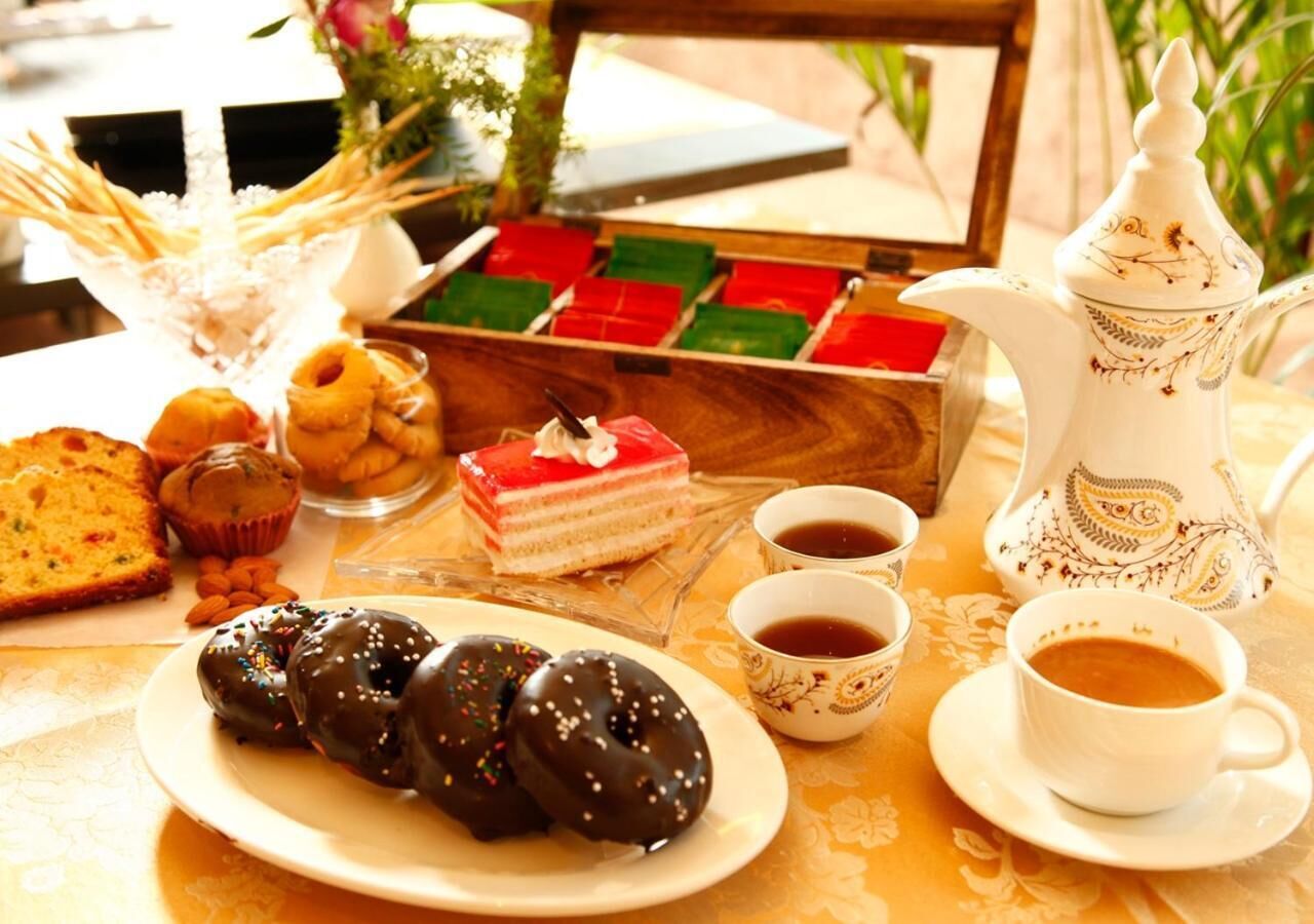 Une table avec des pâtisseries, un gâteau et des tasses de café.