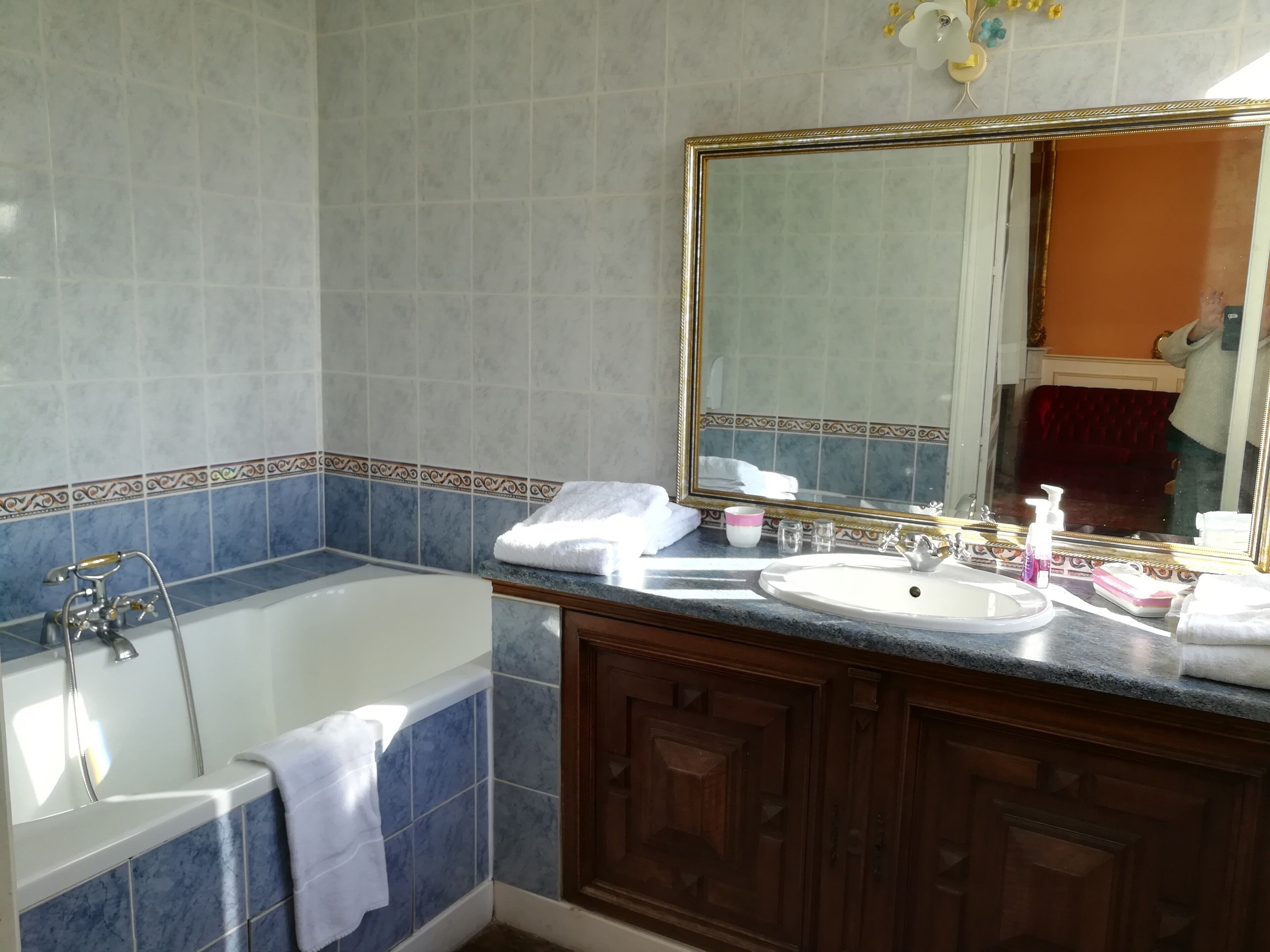 A bathroom with a bathtub, a sink with a mirror, and a vanity with cabinets.