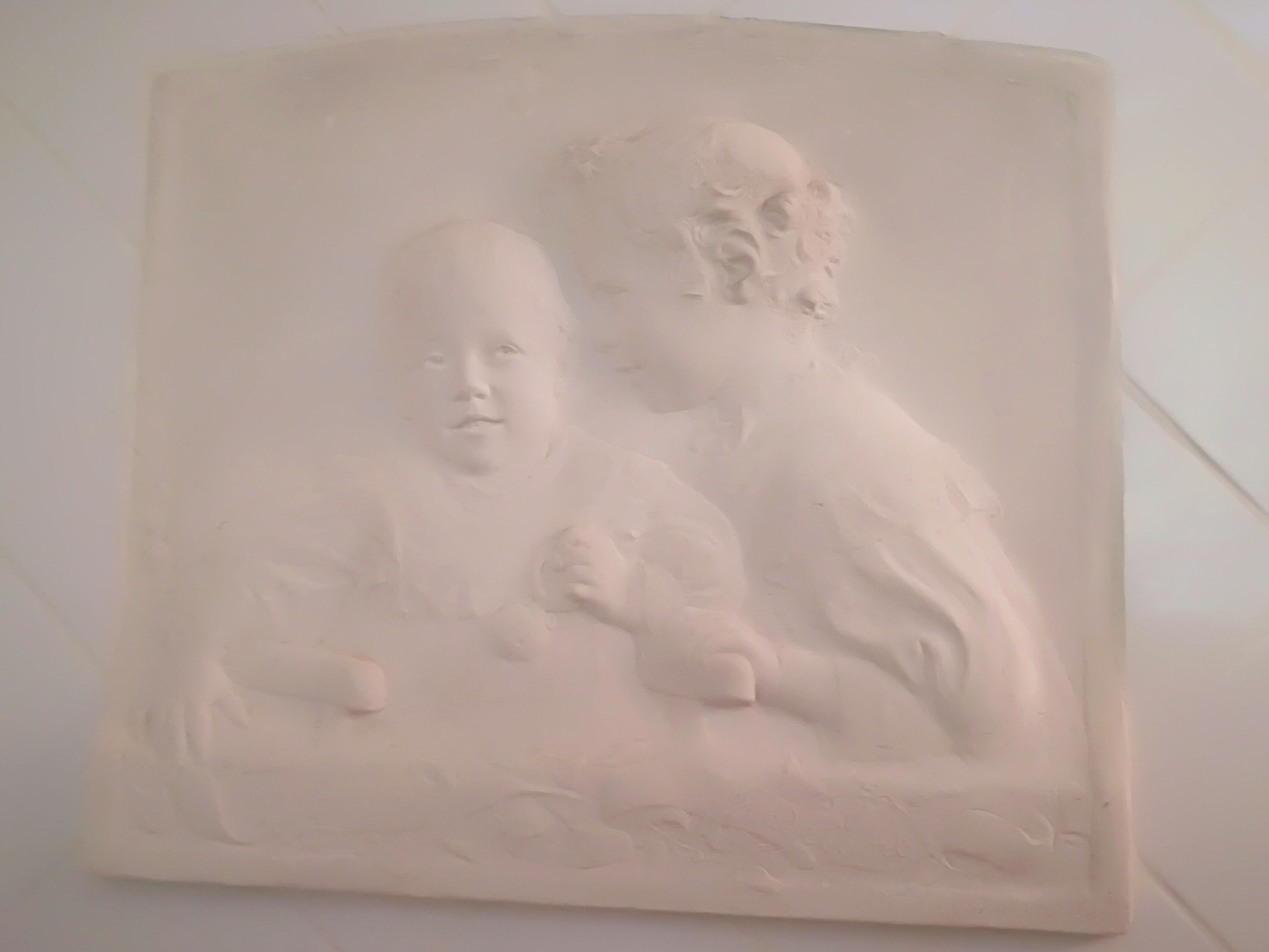 Ein Relief, das eine Frau und ein Kind zeigt.