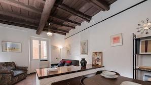Una sala de estar acogedora con un sofá, una mesa de centro y una mesa de comedor con platos y tazones.