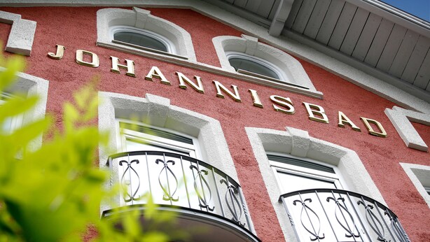 A building facade with the name "JOHANNISBAD" prominently displayed in gold letters. - AKZENT Hotel Johannisbad (Bad Aibling)
