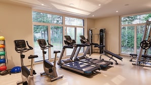 Et fitnesscenter med løbebånd, crosstrainere og styrketræningsudstyr.