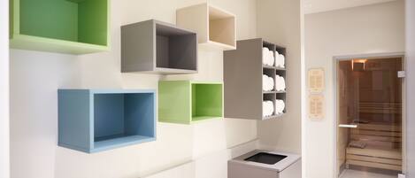 A modern kitchen with built-in shelves in various colors and a small sink.