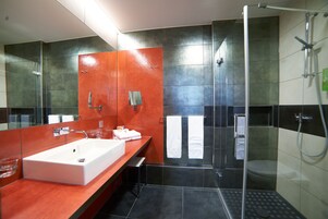 Un baño moderno con un lavamanos grande, ducha e inodoro.