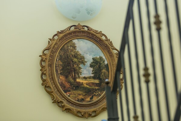 Un cuadro de paisaje enmarcados colgado en una pared.